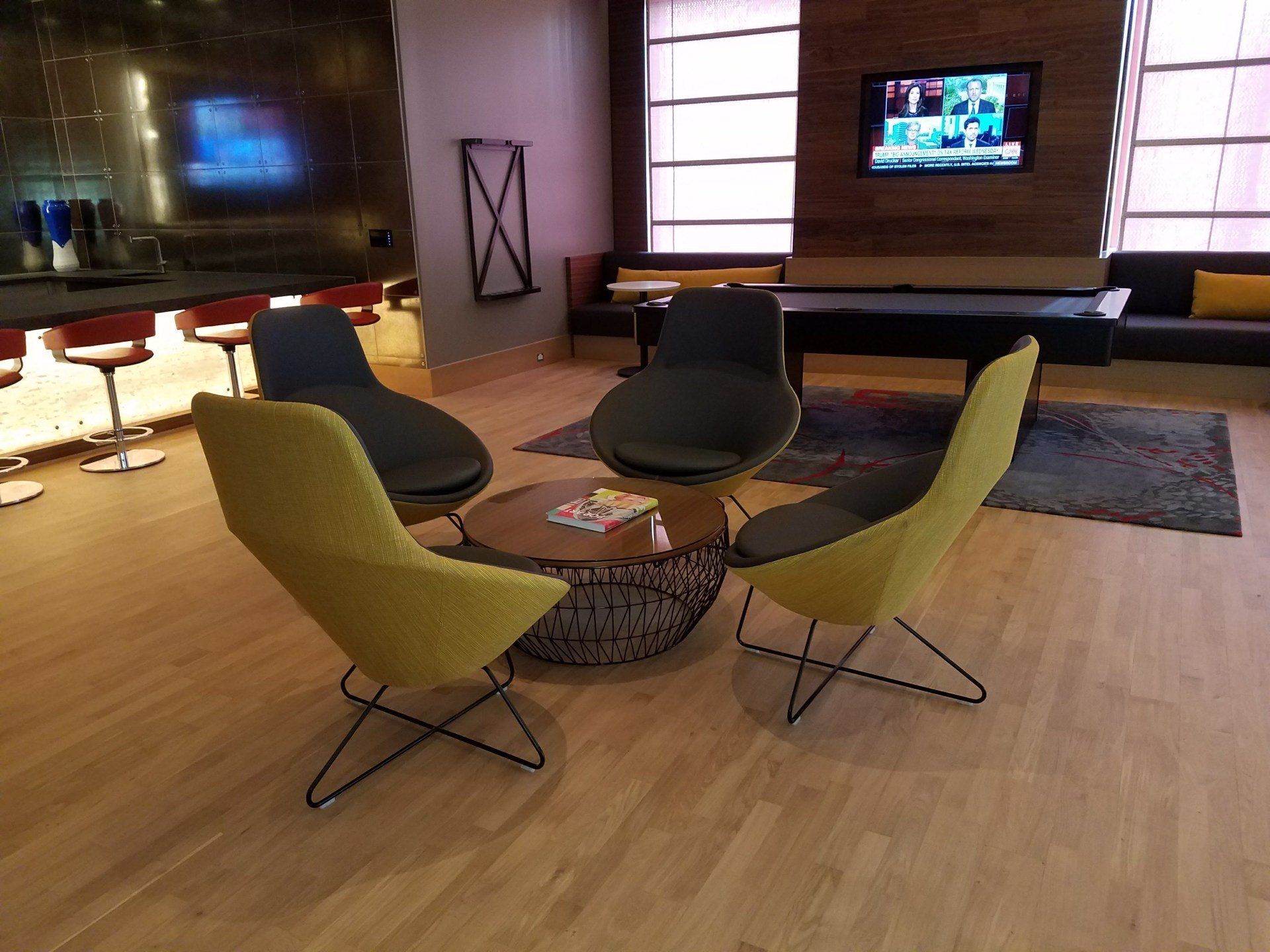 bar lounge area with designer chairs around a low coffe table with bar and barstools by dismantlefurniture