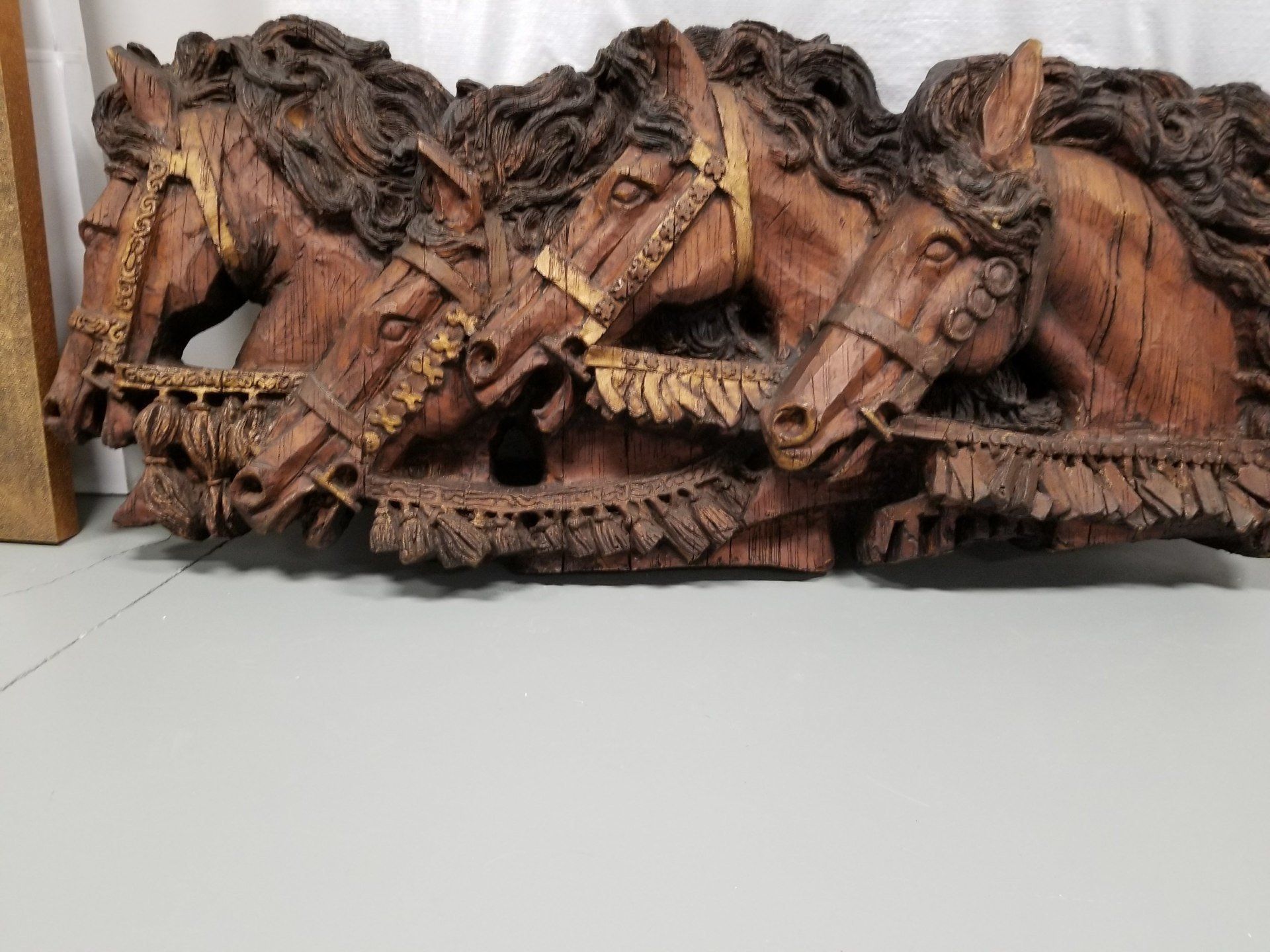 A wood carving of four horses standing next to each other