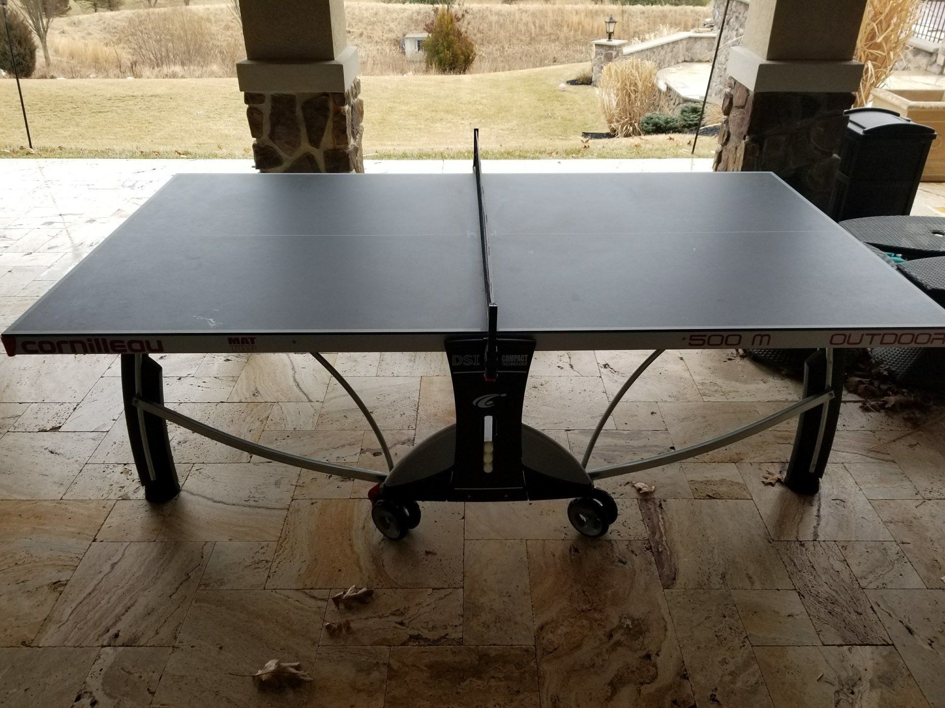 A ping pong table is sitting on a tiled floor