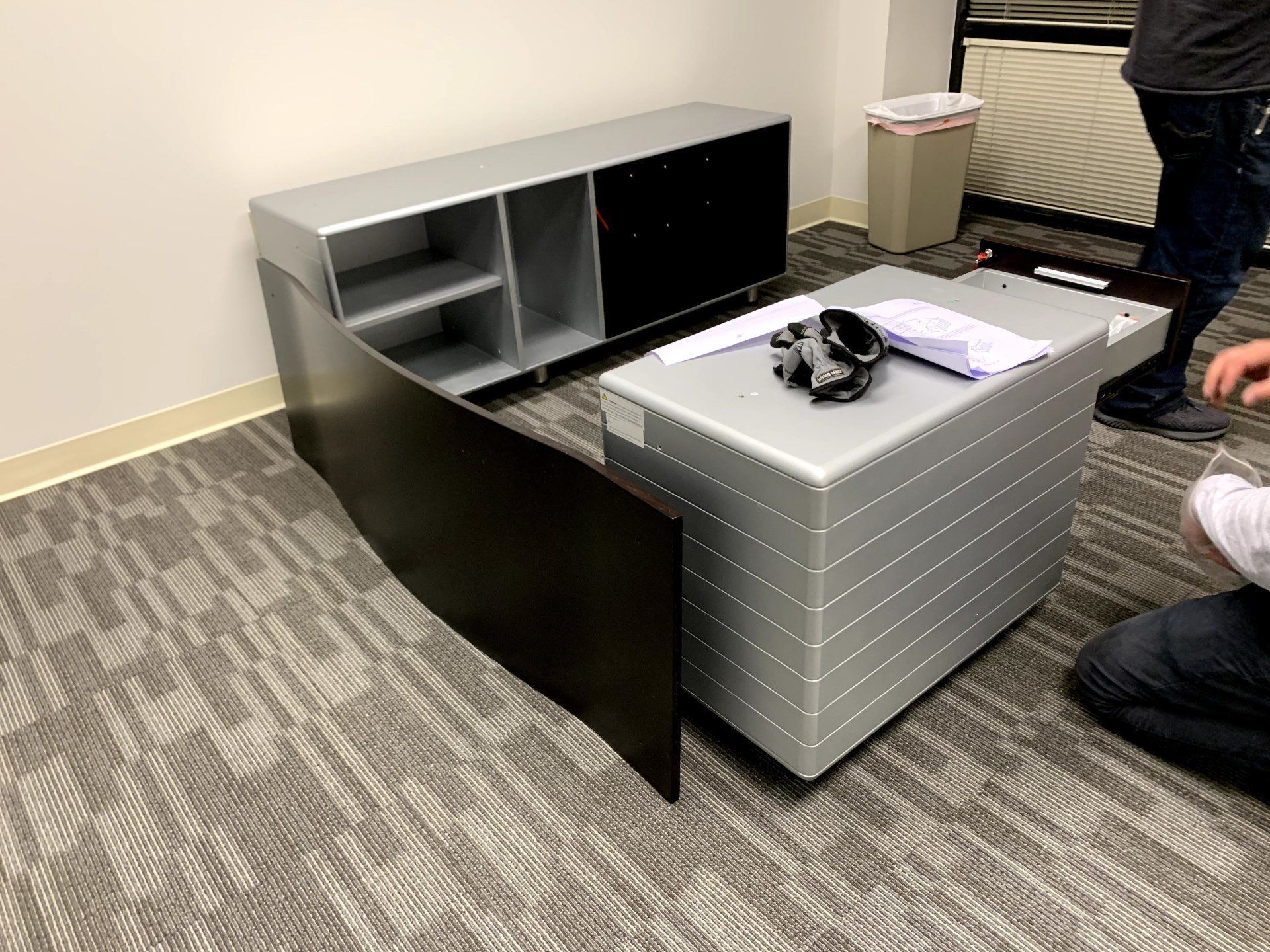 disassembled Right turn black oak ZURI Kennedy desk with gray trim by furniture assembly team