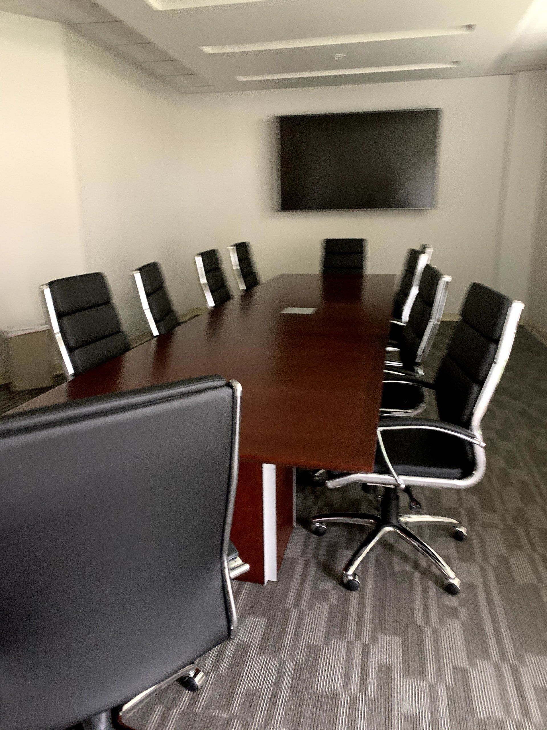ZURI brown polished wood conference room table with elegant black and brushed metal chairs by furniture assembly team
