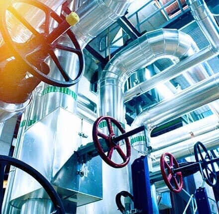 Commercial Pipes Valve — Willingham Plumbing in VALPARAISO, FL Industrial pipes with red and black valves in a bright, modern setting.