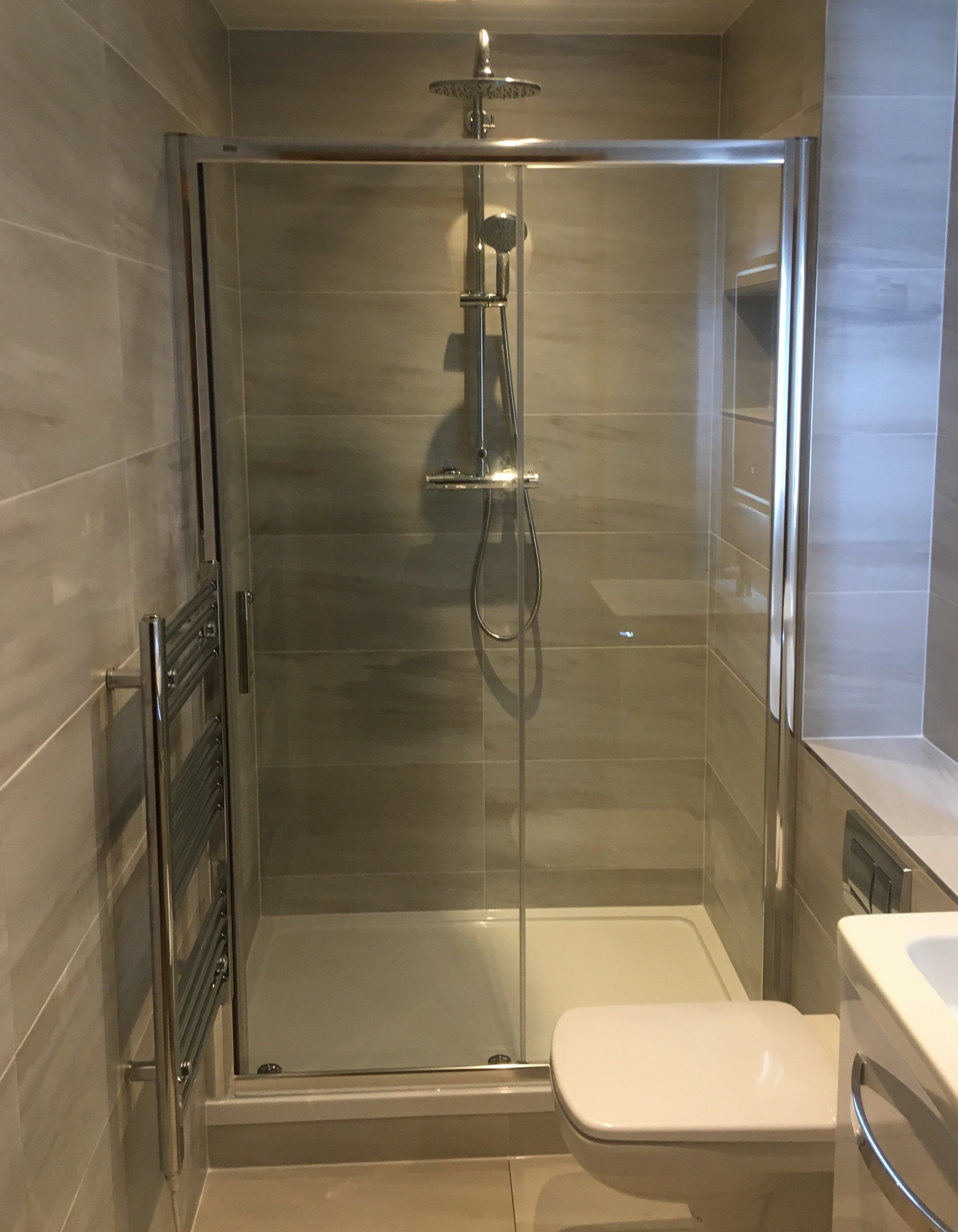 Ensuite bathroom with grey tiles, shower enclosure wall hung WC wall hung vanity unit
