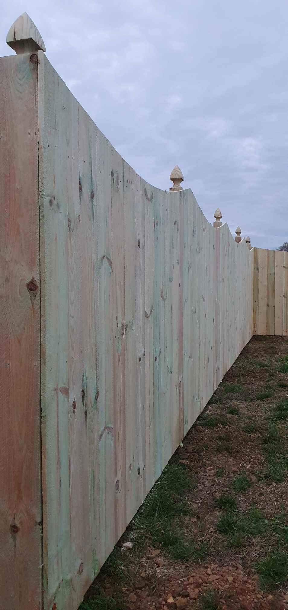 A wooden fence is sitting in the middle of a grassy field.