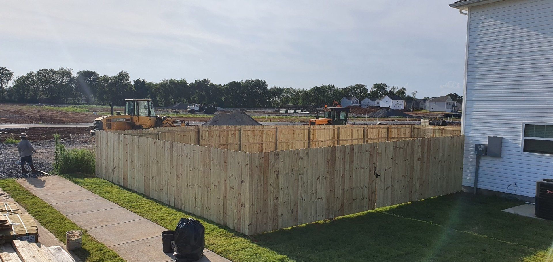 A wooden fence is being built in front of a house.