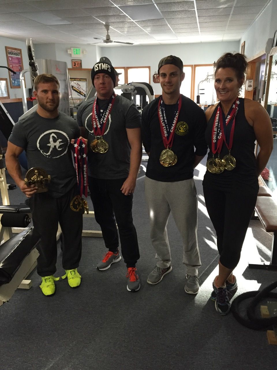 A group of people standing in a gym with medals around their necks