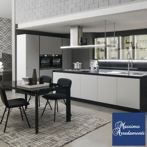 Cucina moderna con mobili bianchi e neri, tavolo da pranzo e tappeto.