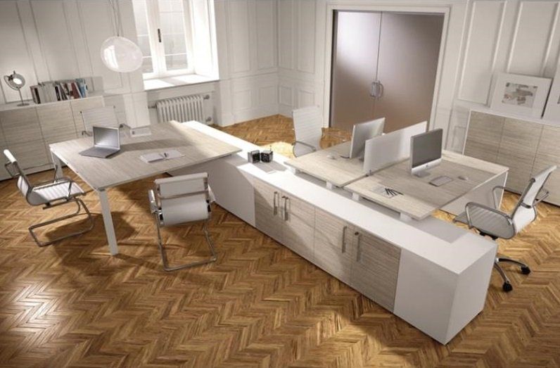 Ufficio moderno con pavimenti e mobili in legno chiaro. Scrivanie con computer, sedie e schedari.