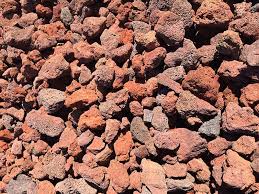 Close-up of rough red and brown volcanic rocks filling the frame.