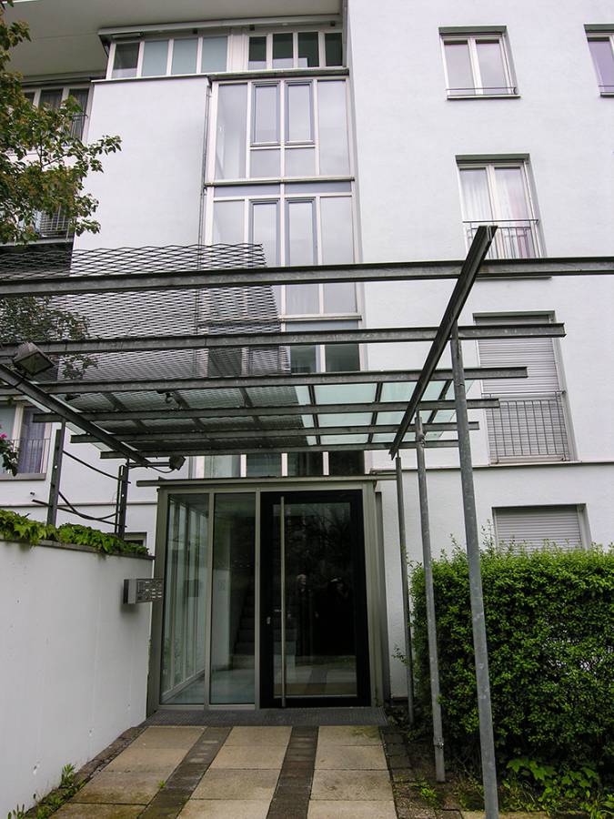 The entrance to a building with a glass canopy over it