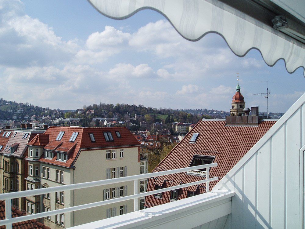 A view of a city from a balcony with a white awning