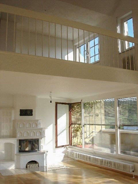 A living room with a fireplace and a balcony