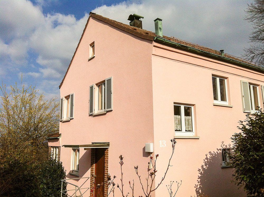 A pink house with a chimney on the roof