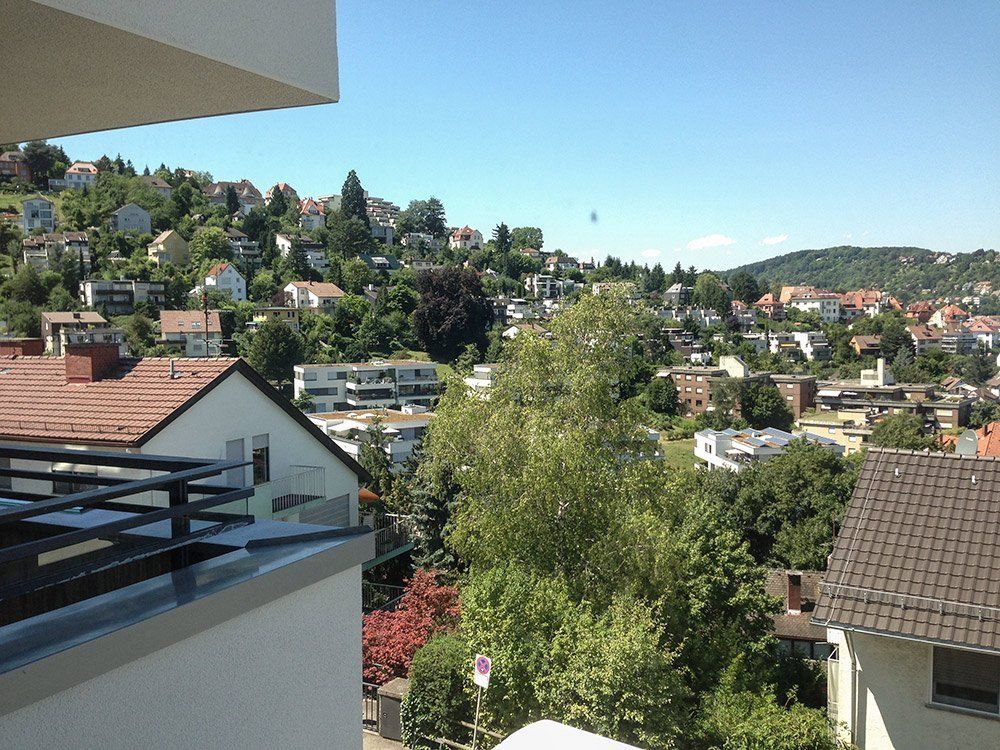 A balcony overlooking a residential area with houses and trees