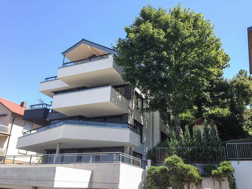 A large apartment building with a tree in front of it