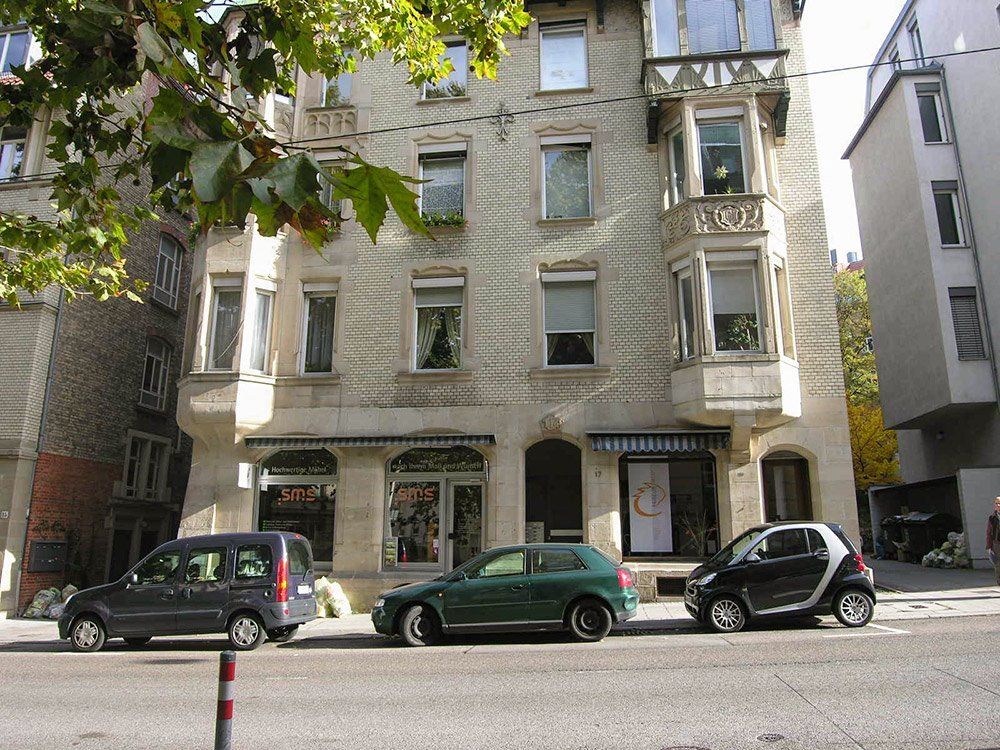 A smart car is parked in front of a building