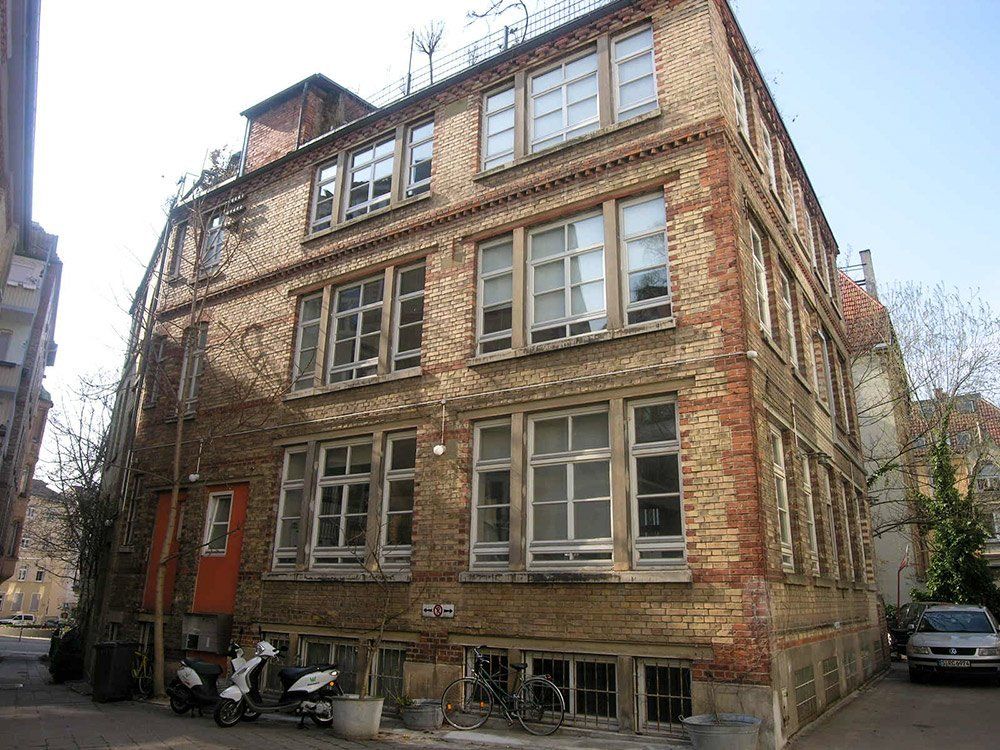 A large brick building with a lot of windows and a motorcycle parked in front of it.