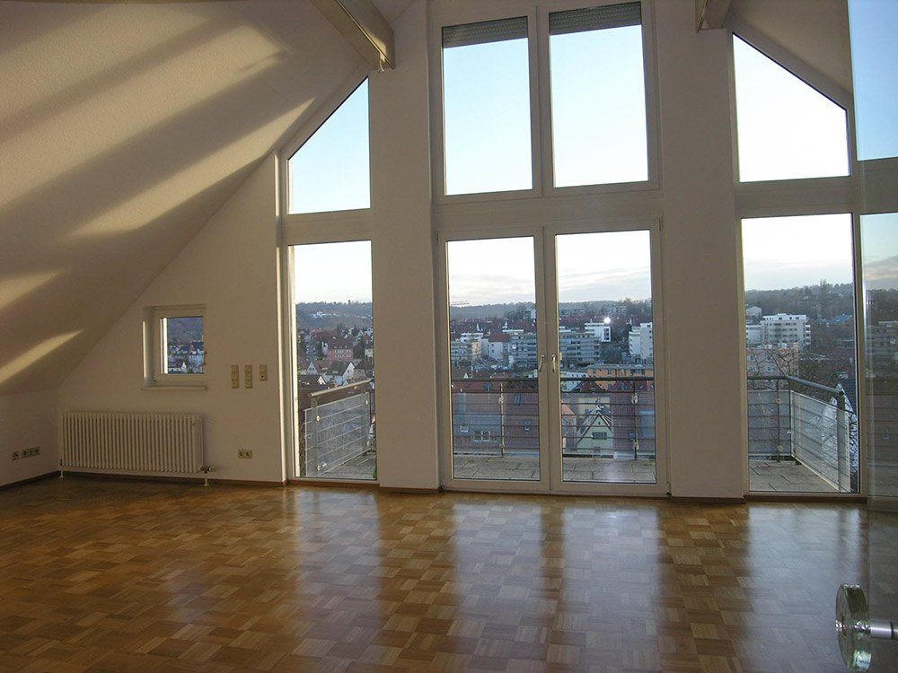 An empty room with a balcony and lots of windows