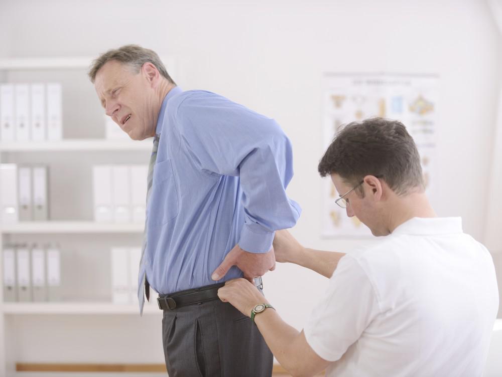 Therapist Checking Man's Back Pain — Cheyenne, WY — Northview Medical Therapist Checking Man's Back Pain — Cheyenne, WY — Northview Medical