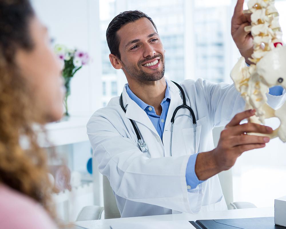 Doctor Showing Human Spine to Client — Cheyenne, WY — Northview Medical Doctor Showing Human Spine to Client — Cheyenne, WY — Northview Medical