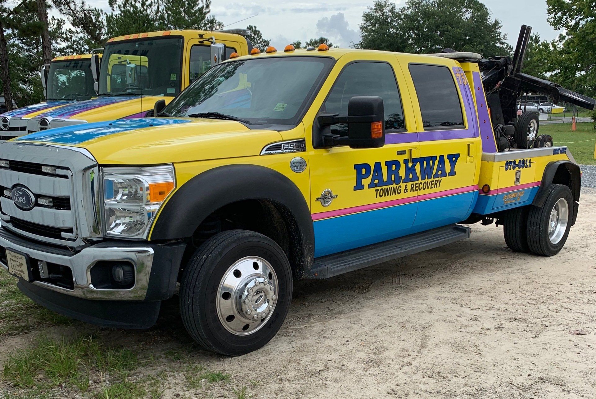 Yellow, blue, and purple Parkway Towing truck with a tow crane.