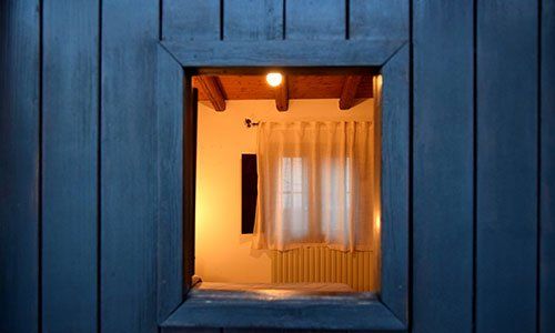 Vista da lontano di una finestra e dentro si vedono dei caloriferi e una tenda