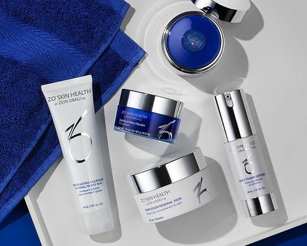 A tray with a blue towel and a variety of cosmetics on it.