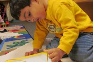 A young boy working on an activity at preschool