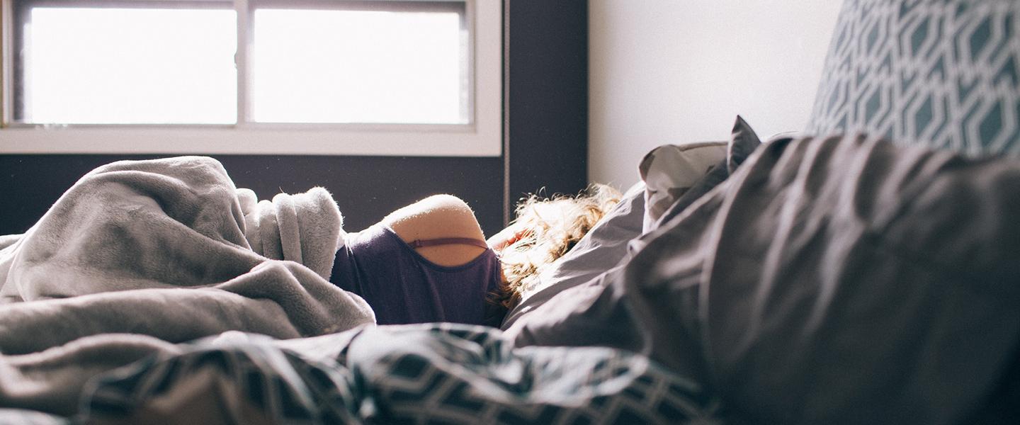 A Class Driving School, Bristol | A person is laying on a bed under a blanket.