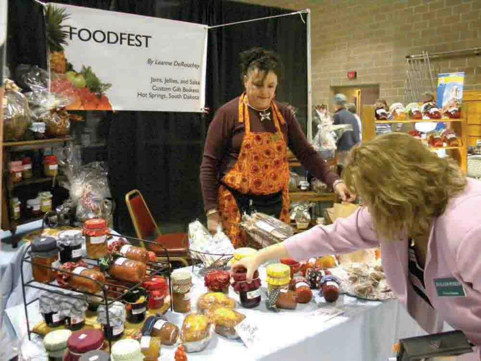 Two women are standing in front of a foodfest sign
