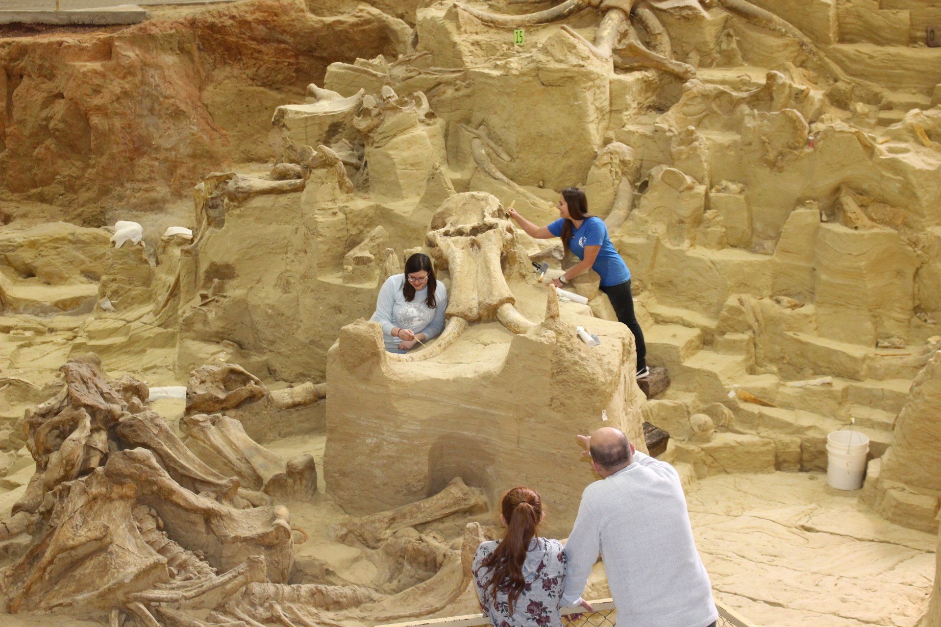 A group of people are standing in front of a sand sculpture.