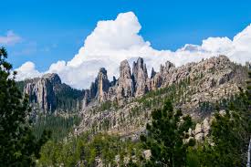 A mountain covered in trees and rocks with a blue sky in the background.