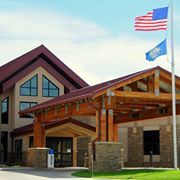 A large building with two american flags flying in front of it.