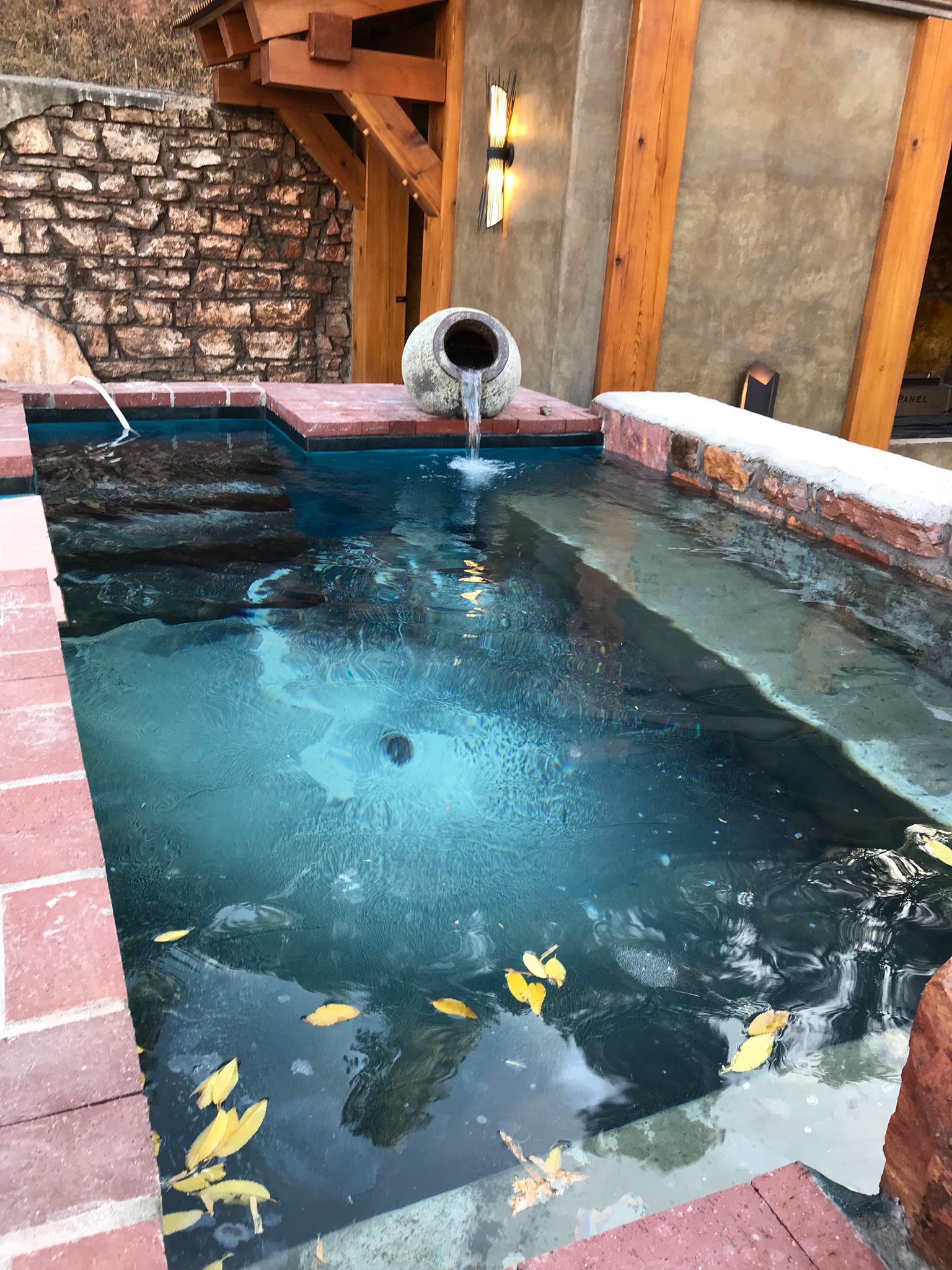 A large swimming pool with a fountain in the middle of it.