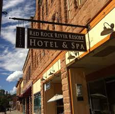 A hotel and spa sign is hanging from the side of a building.