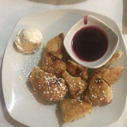 A plate of food with ice cream and sauce on a table.