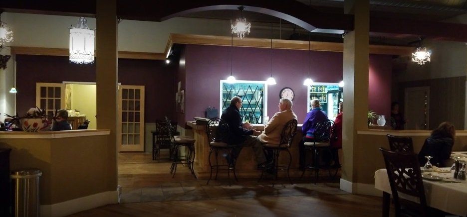 A group of people are sitting at a bar in a restaurant