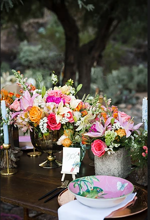 A table with plates , bowls , candles and flowers on it.