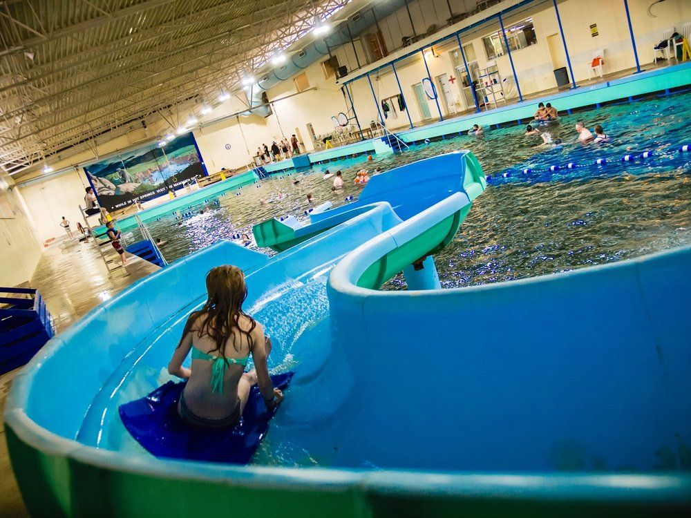 A woman is riding down a water slide at a water park.
