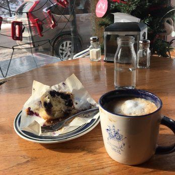 A cup of coffee and a plate of food on a table