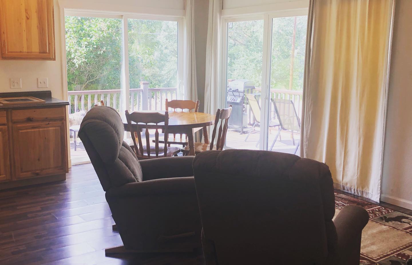 A living room with a couch , chair , table and sliding glass doors.