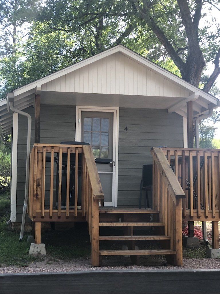 A small house with a wooden deck and stairs.
