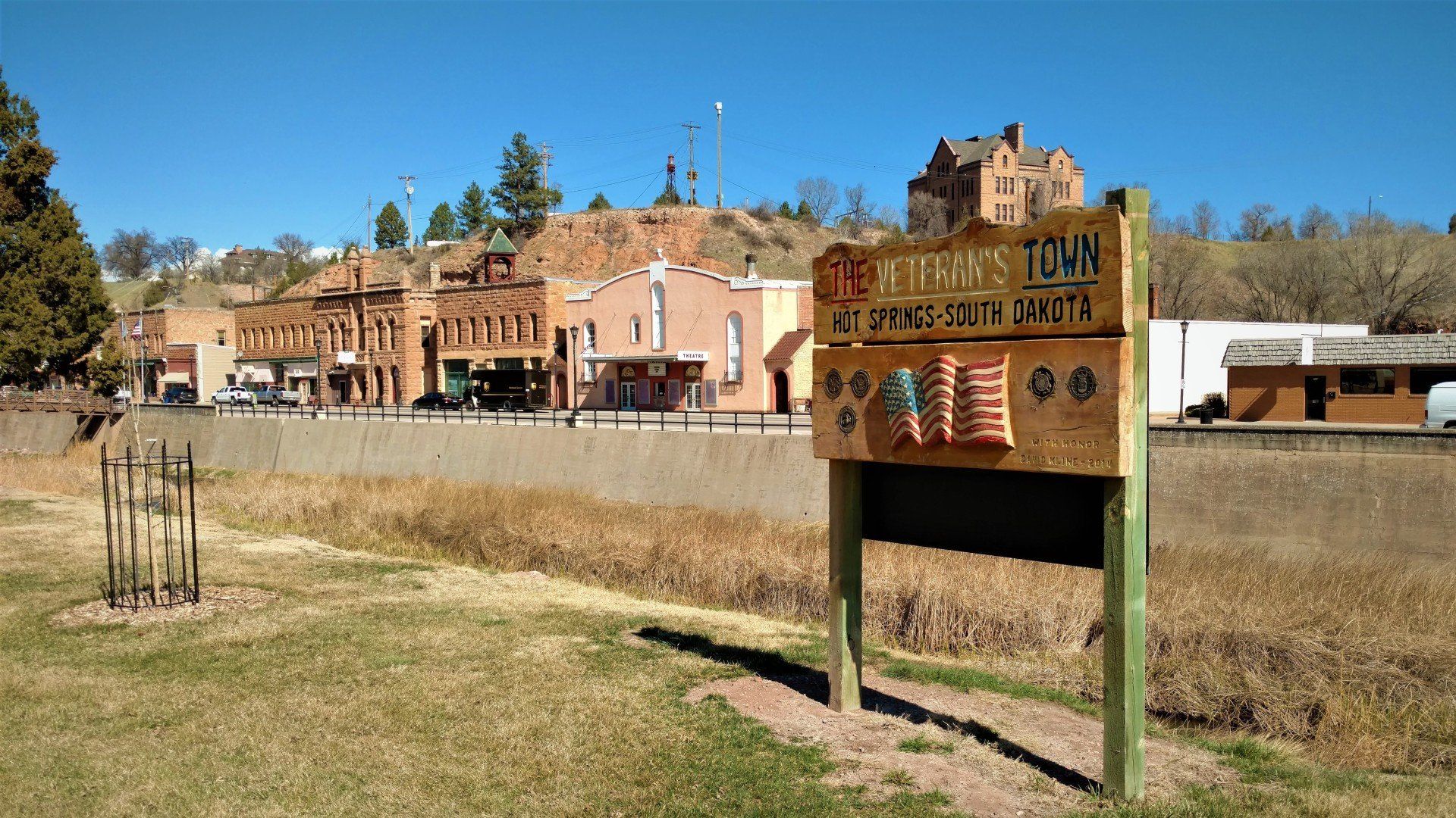 A wooden sign in front of a small town