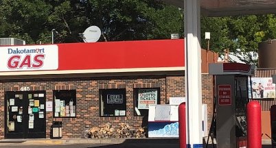 A gas station with a red and white sign on top of it.