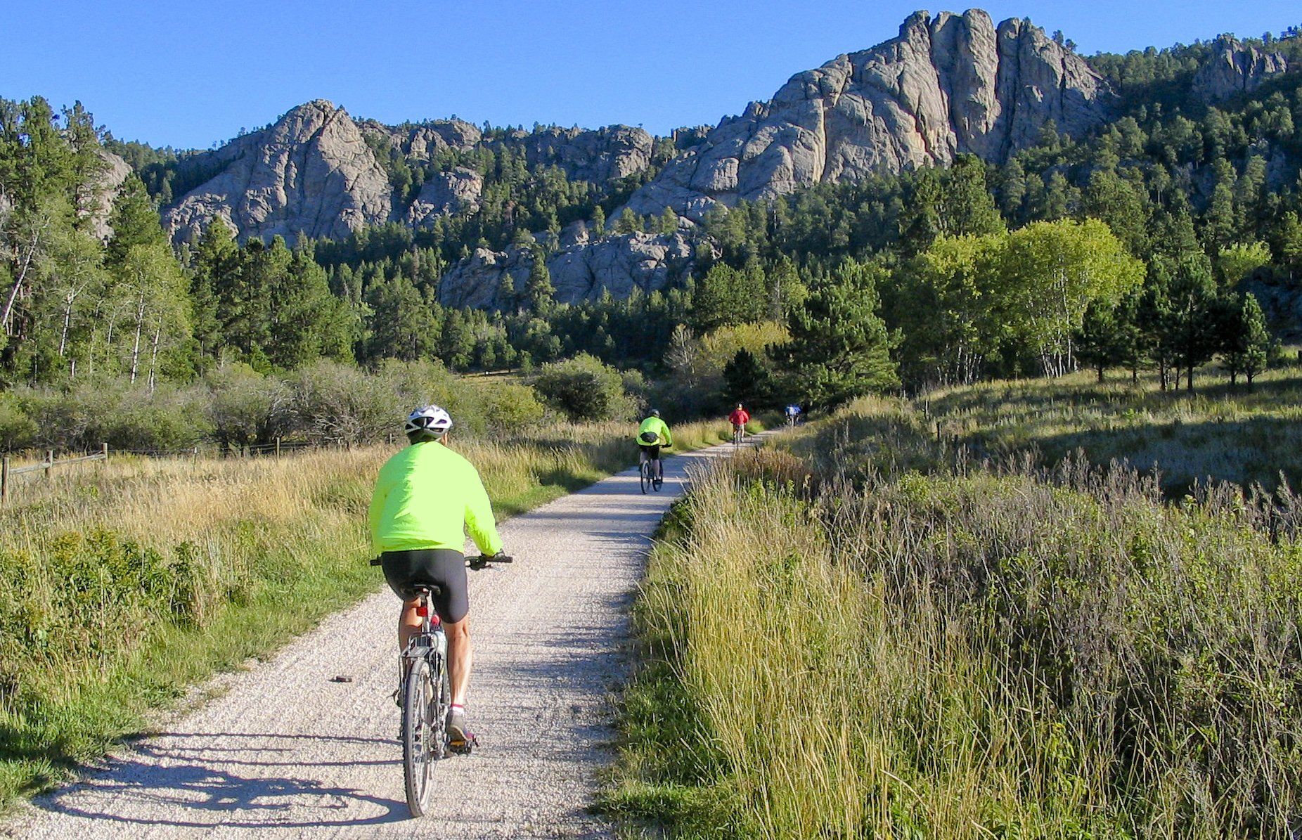 A person is riding a bike down a dirt road