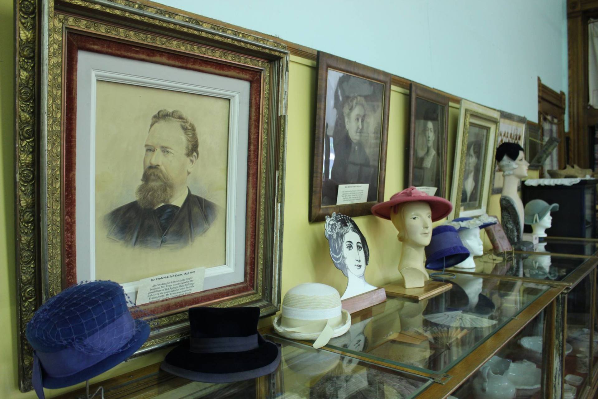 A display case with hats and a picture of a man