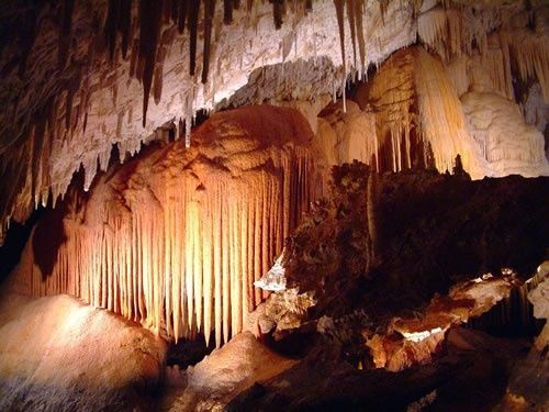 A cave with a lot of stalagmites hanging from the ceiling