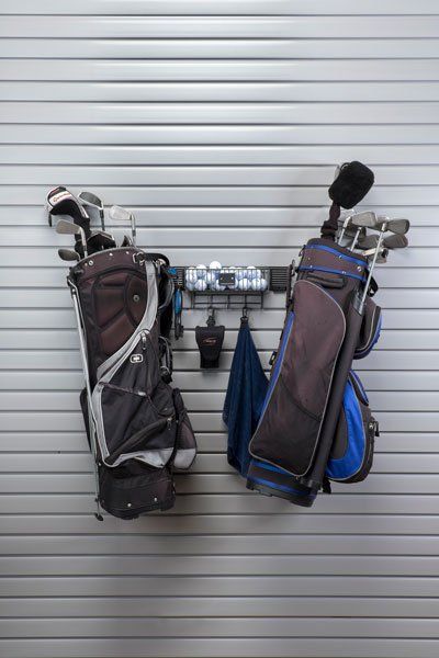 A couple of golf bags hanging on a wall.