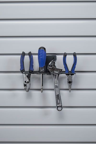 A bunch of tools are hanging on a wall.