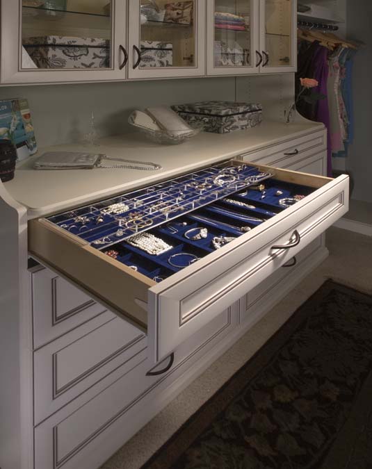 A drawer in a closet filled with lots of jewelry